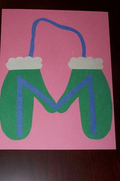 two green mittens with blue handles on a pink background