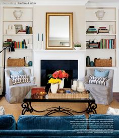 a living room filled with furniture and a fire place in front of a mirror on the wall