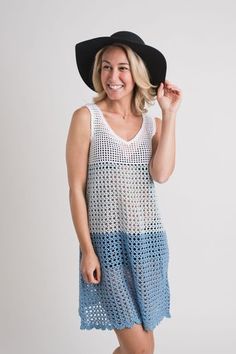 a woman wearing a black hat and blue crochet dress, posing for the camera