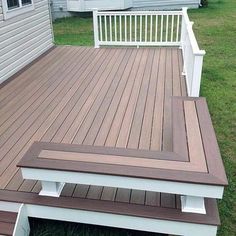 a wooden deck with white railing and steps