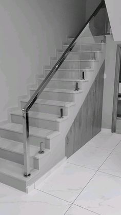 a black and white photo of a stair case next to a door on the wall