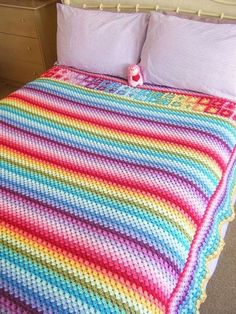 a colorful crocheted blanket on top of a bed