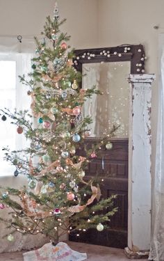 a decorated christmas tree in front of a mirror