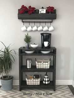 a coffee bar with cups and mugs on the top shelf next to potted plants