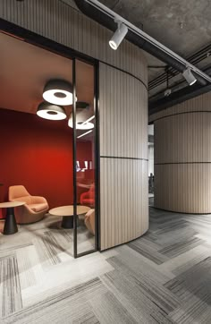 an office with red walls and wooden flooring in the center, along with modern furniture