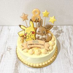 a pokemon themed birthday cake with pikachu and eebi on it's top