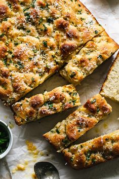 slices of bread with herbs and parmesan sprinkles on the side