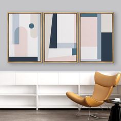 two abstract paintings hang on the wall above a coffee table in a modern living room