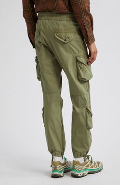 Relaxed-fit cargo pants are equipped with eight pockets, featuring grommets, rivets and snaps throughout for an authentic utilitarian feel. Cut from lightweight cotton poplin, these pants feature a pinched-seam technique before the garment-dye and wash process, revealing subtle variations in color after the pinching is released. 31" inseam; 14" leg opening; 12" front rise; 16" back rise (size Medium) Elastic/drawstring waist Front slant pockets; cargo bellows snap-flap pockets with internal draw Combat Cotton Cargo Pants, Combat Cotton Parachute Pants With Multiple Pockets, Cotton Cargo Combat Bottoms, Cotton Combat Cargo Bottoms, Khaki Cotton Cargo Jeans With Belt Loops, Combat Cotton Pants With Cargo Pockets, Combat Style Cotton Cargo Pants With Multiple Pockets, Utility Cargo Pants With Flap Pockets, Military Style Cotton Parachute Pants With Multiple Pockets