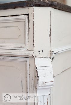 an old white dresser with peeling paint on it