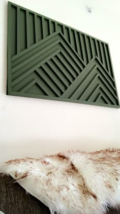 an animal fur rug sitting on top of a couch next to a wall mounted art piece