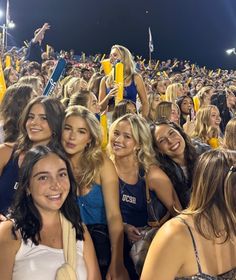 a group of young women standing next to each other in front of a large crowd