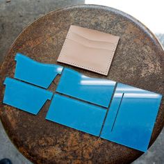 a piece of blue paper sitting on top of a table next to a leather wallet