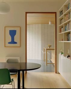 a dining room table and chairs with bookshelves in the background