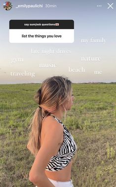 a woman standing in the middle of a field with her back turned to the camera