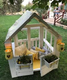 a doll house made out of pallets and some plants