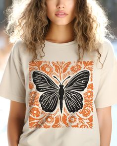 Vintage butterfly Botanical Shirt, Folk art linocut like shirt, Wildflowers tee shirt,Cute butterfly t-shirt, Cottage Core floral shirt This classic unisex jersey short sleeve tee fits like a well-loved favorite. Soft cotton and quality print make users fall in love with it over and over again. These t-shirts have-ribbed knit collars to bolster shaping. The shoulders have taping for better fit over time. Dual side seams hold the garment's shape for longer.  .: 100% Airlume combed and ringspun cotton (fiber content may vary for different colors) .: Light fabric  .: Retail fit .: Tear away label .: Runs true to size SIZE  Unisex Style fro S-3XL PROCESSING TIME 1-7 business days (Depends on the Holidays and stock) PRINTING PROCESS Discover the future of eco-friendly printing with us! Our DTG Butterfly Botanical, Butterfly T Shirt, Botanical Shirt, Cute Butterfly, Flower Graphic, Vintage Butterfly, Floral Shirt, Linocut, Cottage Core