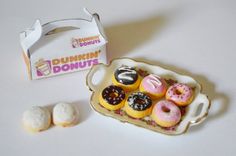 miniature donuts are sitting on a plate next to a box of doughnuts