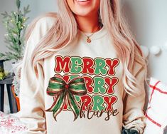 a woman with long blonde hair wearing a merry sweatshirt