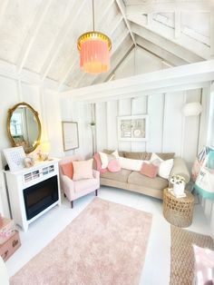 a living room filled with furniture and a pink rug on top of a white floor