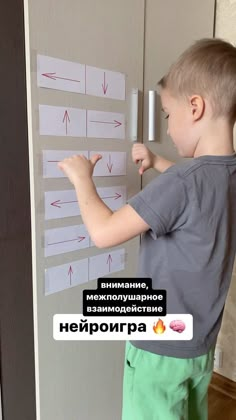 a young boy standing in front of a refrigerator with magnets on it's side