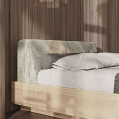 a bed with white sheets and pillows in a room that has wood paneling on the walls