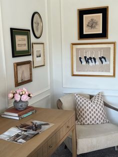 a living room filled with furniture and framed pictures on the wall above a coffee table