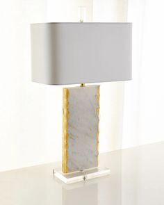 a marble lamp on a table with a white and gold shade over the light fixture