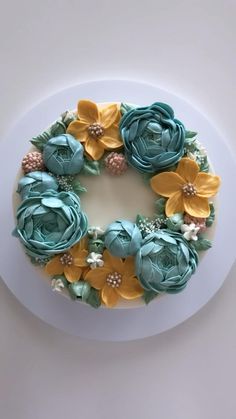 a cake decorated with flowers on top of a white plate and blue frosted icing