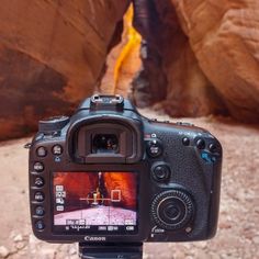 a camera that is sitting on a tripod in front of some rocks and water