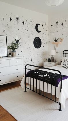 a bed room with a neatly made bed and stars on the wall