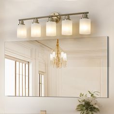 a bathroom vanity with a mirror and lights above it