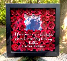 a photo frame made out of red paper roses