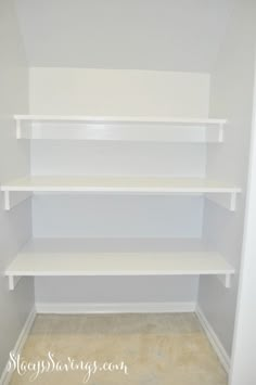 an empty closet with white shelves in it