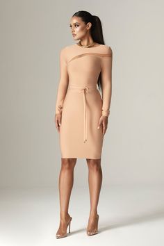 a woman wearing a nude colored dress with long sleeves and an asymmetrical neckline