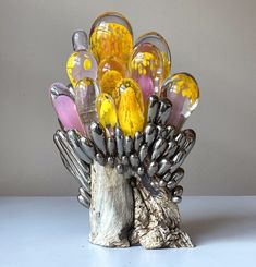 a botanical sculpture of a flower, made from glass, wood, and ceramics