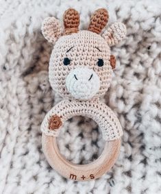 a crocheted giraffe toy with a wooden ring