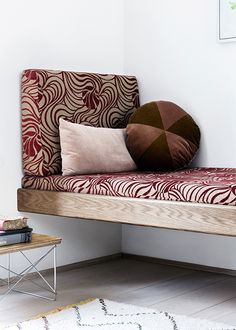 a wooden bench with pillows on top of it