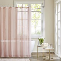 a bathroom with a tub, shower curtain and rug in front of the bathtub