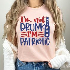 a woman wearing a pink shirt that says i'm not drunk i'm patriotic