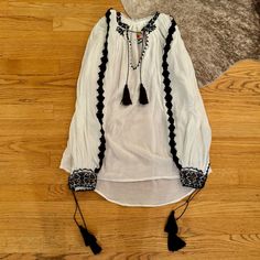 Fiori De Ie Romanian Peasant Folk Blouse Black White Bnwot Size S/M - Fits Up To Us 6 Retail: $165 Gorgeous Handmade Cotton Blouse Tassel Tie Closures At Neck And Wrists Black Embroidery Detail On Sleeves Black Embroidery Around Neck And Wrists Also Have Colorful Beadwork Colorful Brand Embroidery At Back Gift From Romania Shopping Bag Included - Note Faint White Marks In Photos Like It? Make An Offer! Combine With Other Items To Save On Shipping No Trades From Website: This Shop Sells Clothing Cotton Peasant Top For Fall Vacation, Cotton Peasant Top For Vacation In Fall, Fall Cotton Peasant Top For Vacation, Fall Beach Peasant Tunic Top, Fall Vacation Peasant Dress With Long Sleeves, Long Sleeve Peasant Dress For Fall Vacation, Folk Style Peasant Top With Boho Collar, Cotton Folk Peasant Top For Beach, Folk Style Cotton Peasant Top For Vacation