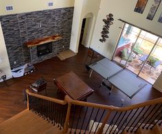 an aerial view of a living room with wood floors and stone fireplace in the center