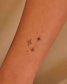 a woman's leg with three small stars on the left side of her arm