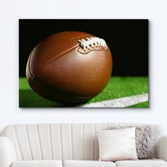 a football sitting on top of a field next to a white couch