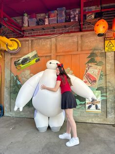 a woman standing next to a giant inflatable bear