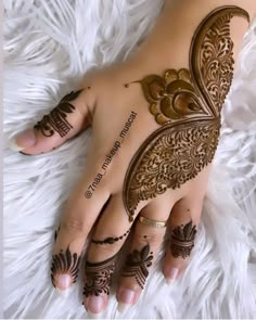 a woman's hand with henna tattoos on it and the words written in arabic