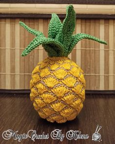 a crocheted pineapple sitting on top of a wooden table