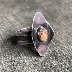 An absolutely Gorgeous Modernist Ring, made of Sterling Silver & Oval Striped Agate. Size 9.25  This is a stunning example of the Mid Century Danish Modernist aesthetic.  This piece was made c1960's in the style of  famed Danish Jeweler Georg Jensen or Carl Ove Frydensberg.  It is unstamped but tests as Sterling. A truly one of a kind ring you won't find anywhere else.  size US 9 1/4 Adjustable Oval Ring, Unique Ring With Large Stone, Unique Oval Rings With Natural Stones, Modernist Oval Gemstone Rings, Oval Gemstone Rings In Modernist Style, Artisan Agate Oval Ring, Modernist Handmade Adjustable Rings, Unique Oval Agate Rings, Modernist Adjustable Handmade Rings