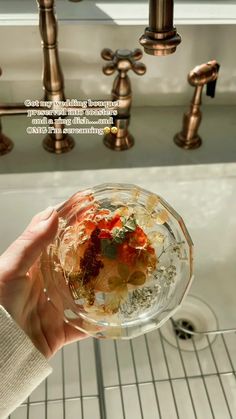 a person holding a bowl with food in it near a sink and faucet