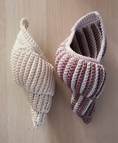 two crocheted baskets sitting next to each other on a wooden surface, one is made out of yarn